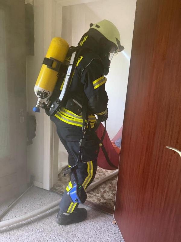 Mehrere Feuerwehrleute stehen vor dem Plakat des Zieles